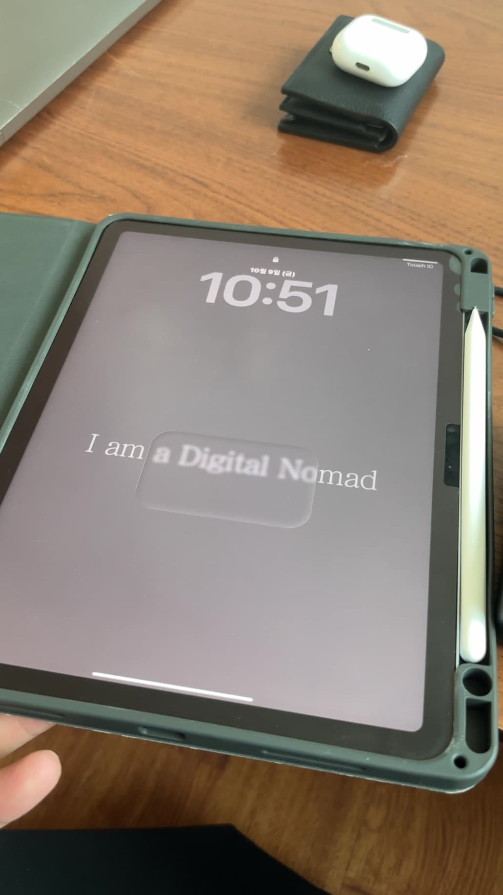 잠금 화면에 I am a Digital Nomad 문구가 떠 있는 아이패드와 애플펜슬